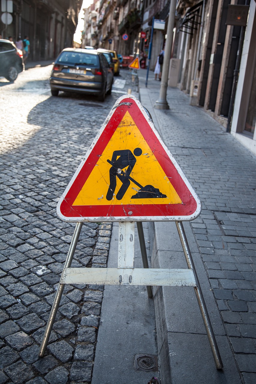 Obras,señal trafico,rojo,amarillo,negro,calle,adoquines,vehículo